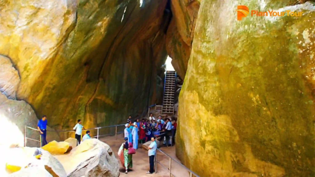 a group of people standing in at Edakkal  caves, worth visiting places in Wayanad
