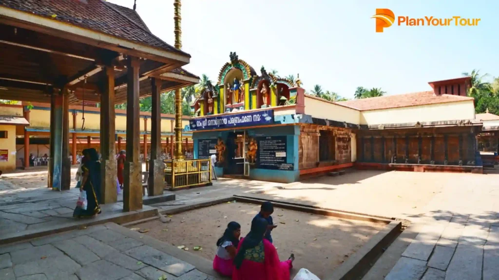 a group of people sitting in a courtyard of Janardanaswamy Temple , famous site to visit in Varkala
