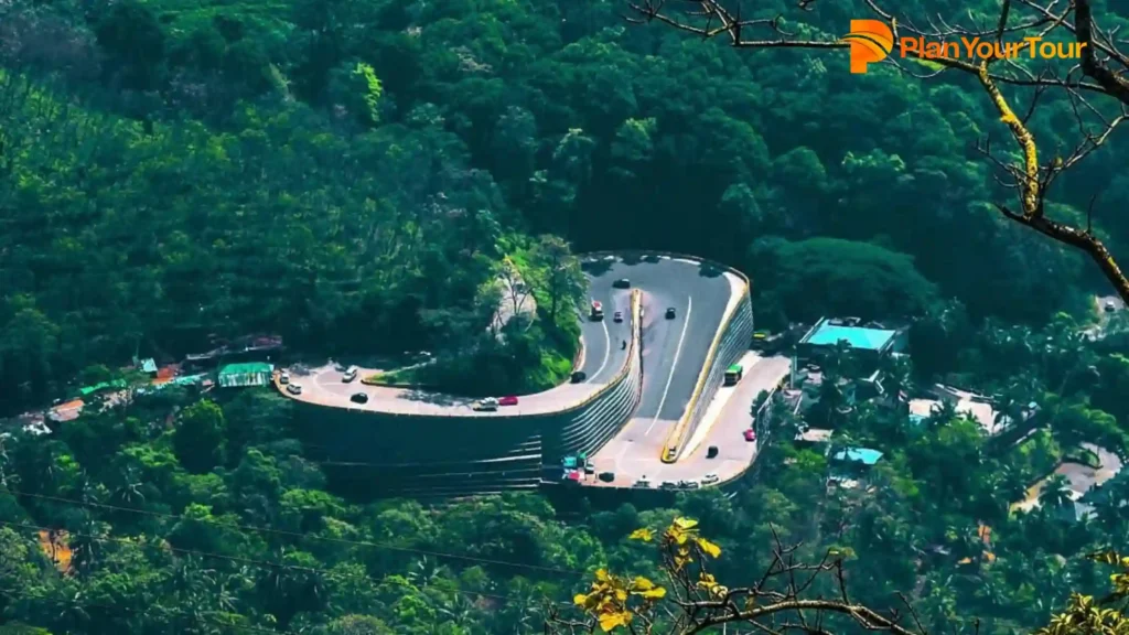 a road with cars on it surrounded by thick forest at Lakkidi View Point, best spots in Wayanad
