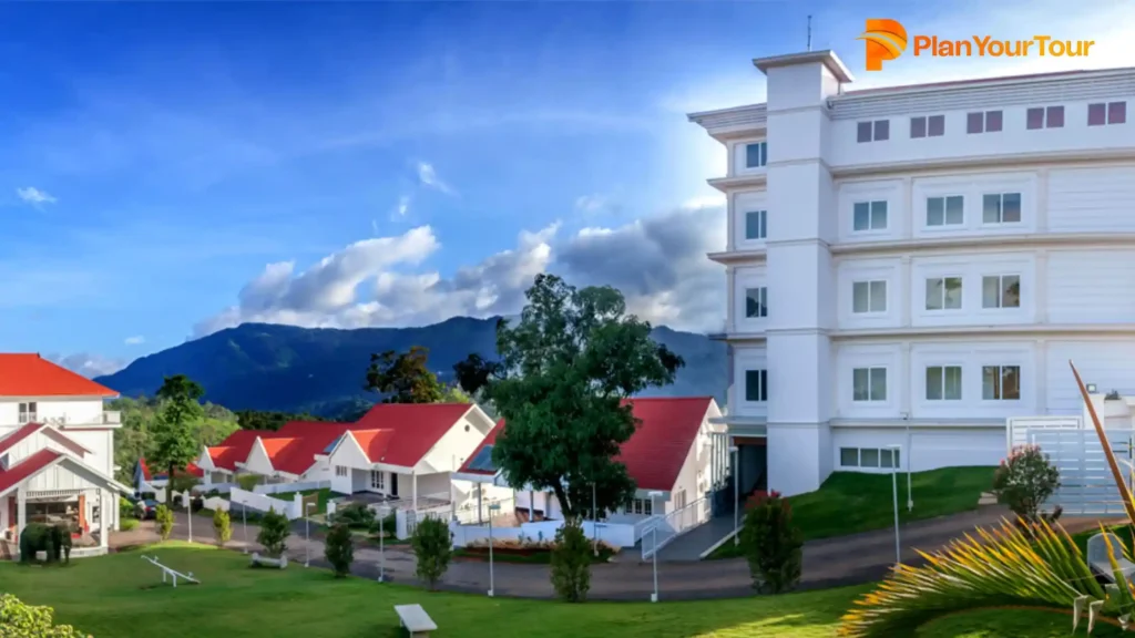 a white building with red roofs and a road of The Fog Munnar Resort & Spa, eco-friendly resort in Munnar
