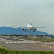 A commercial jetliner takes off from an airport runway, showcasing its powerful engines and upward trajectory.